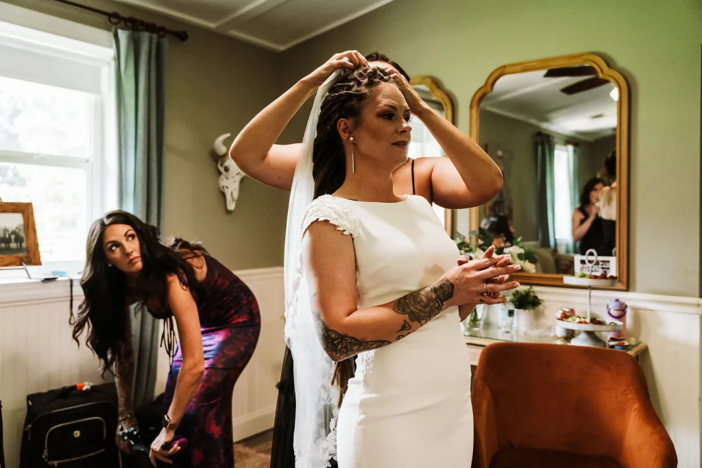The bride has her veil adjusted in the bridal suite at Masters Stables before the ceremony.